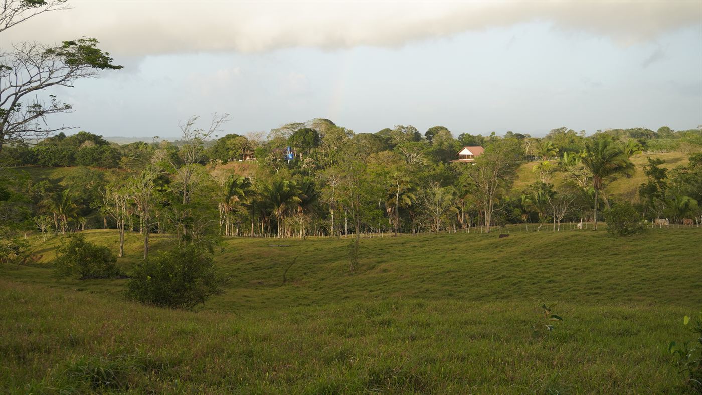 Paisaje de la finca SELAH con arcoíris sobre las colinas